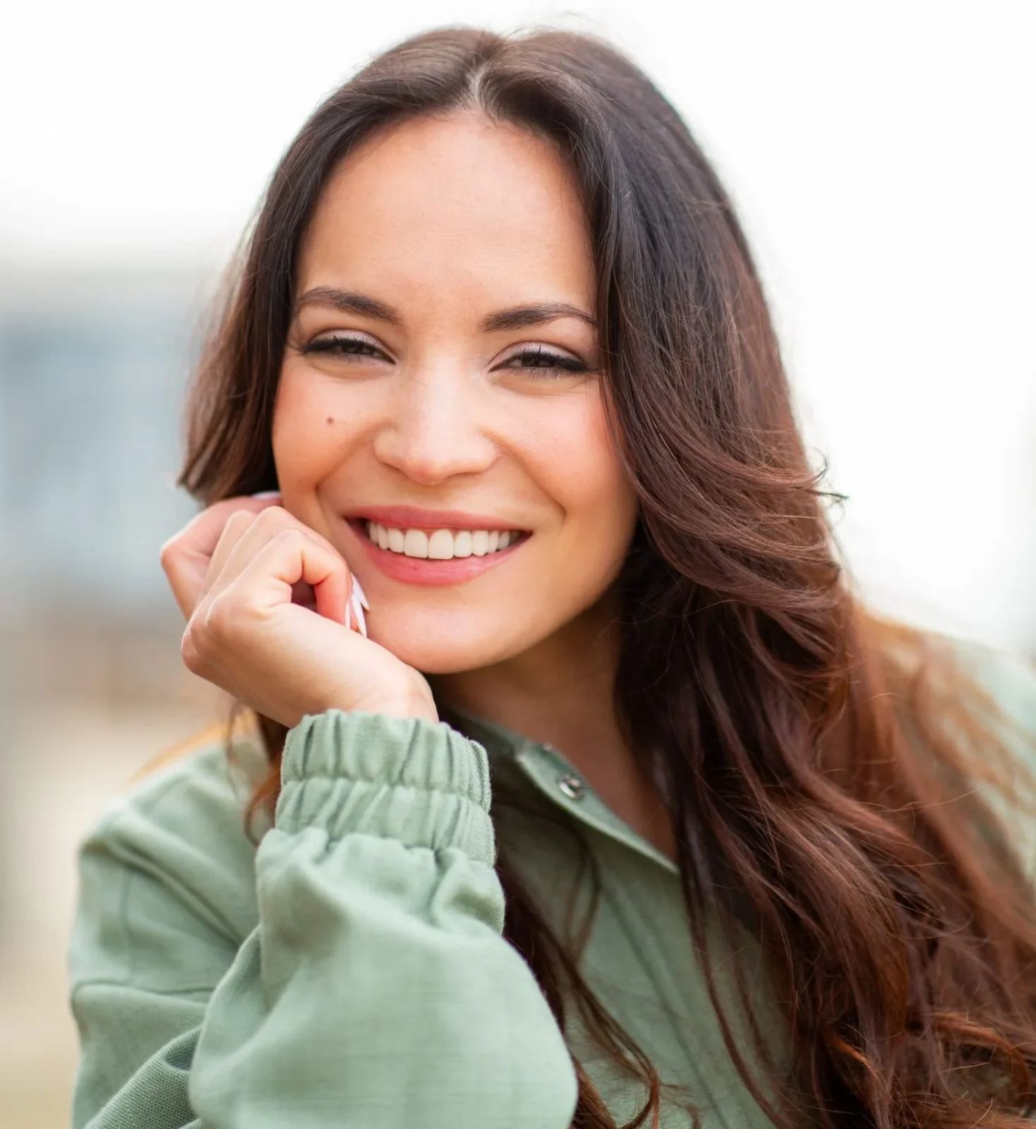 Woman smiling outdoors with clear, healthy skin